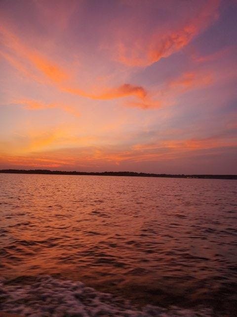 Vivid pink and orange sunset over Lake Conroe at Venice On The Lake